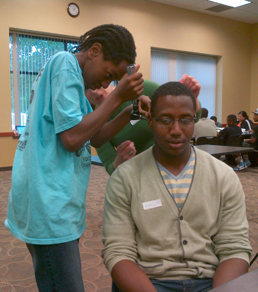 Medical scholar Christopher demonstrating use of an otoscope